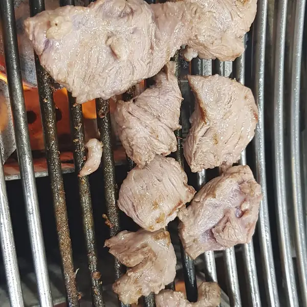 Barbeküde domuz eti pişirmek.