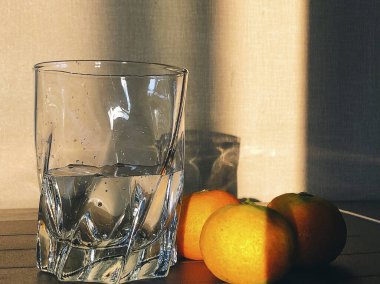 Masanın üzerinde bir bardak portakal ve limon