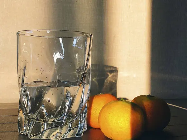 Masanın üzerinde bir bardak portakal ve limon