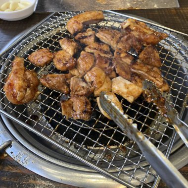 Siyah bir kasede ızgara tavuk bacağı.