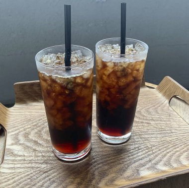 Ahşap bir masada buzlu kahve ve buz.