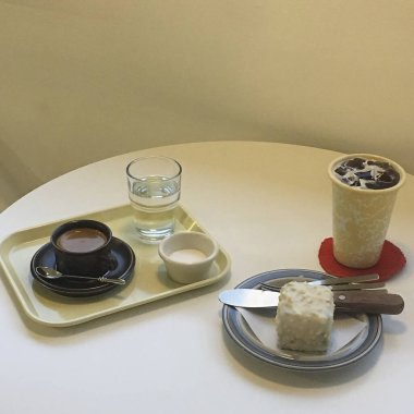 Kahve fincanı, sütlü kahve fincanı ve kek.