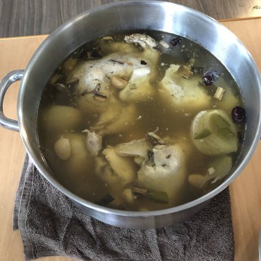 Dikey bir porsiyon leziz tavuk çorbası, beyaz bir kasede.