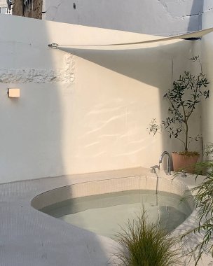 Beyaz bir vazoyla açık havuzun dikey yakın çekimi.