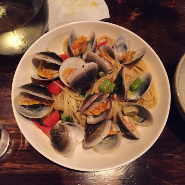 Deniz ürünleri soslu spagetti ve tabakta sebze.