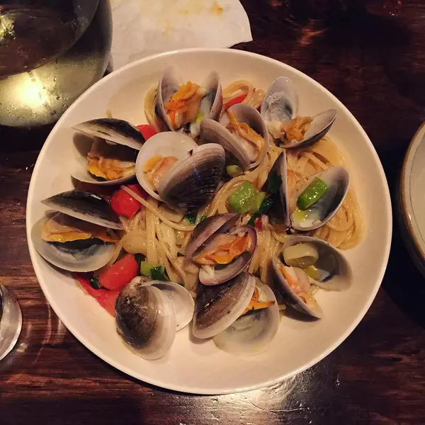 Deniz ürünleri soslu spagetti ve tabakta sebze.