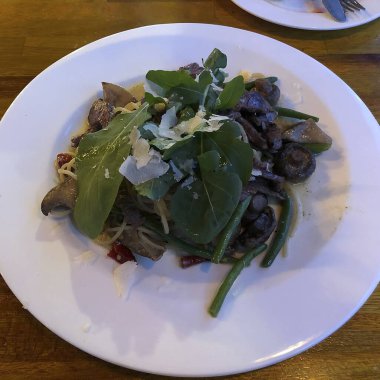 Restoranda bir tabakta mantarlı ve otlu makarna.