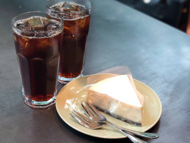 Bir fincan kahve, bir bardak su ve masada bir kaşık.