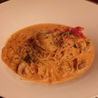 Tabakta deniz ürünleri ve peynirli spagetti.