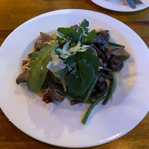 Restoranda bir tabakta mantarlı ve otlu makarna.