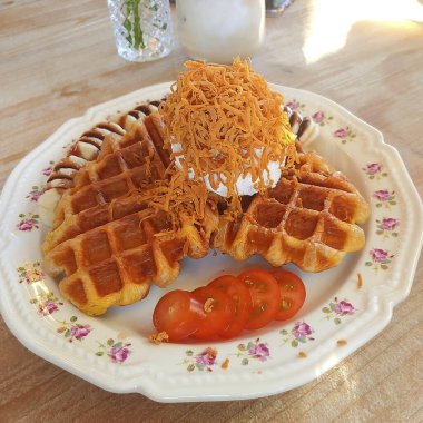 Tahta bir masada çatalla tereyağlı kremalı waffle.