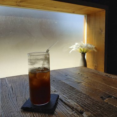 Tahta masada bir bardak buz ve kahve.