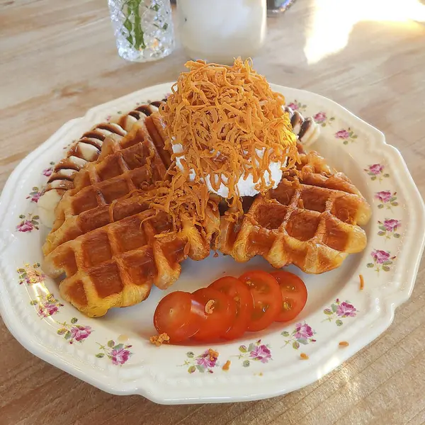 Tahta bir masada çatalla tereyağlı kremalı waffle.