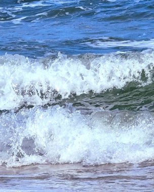 Kumlu sahilde deniz dalgaları