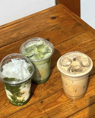 Bir bardak kahve, bir fincan çay ve ahşap bir masada pipet.