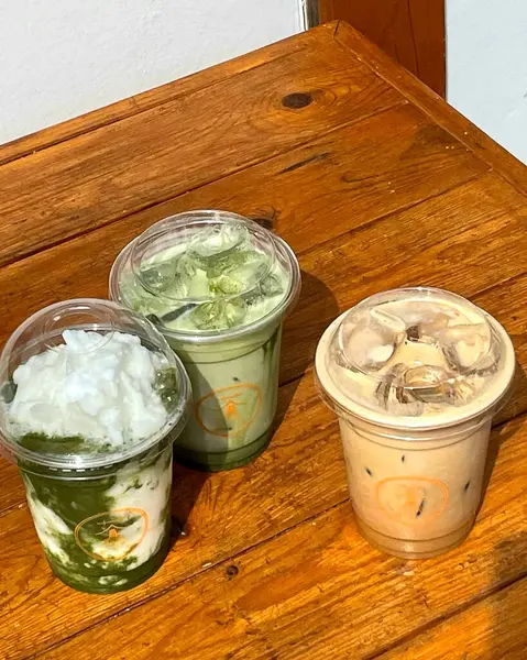 Bir bardak kahve, bir fincan çay ve ahşap bir masada pipet.