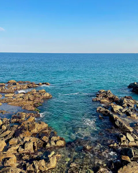 İsrail 'in kuzeyindeki deniz kıyısında mavi gökyüzü olan büyük bir taş.