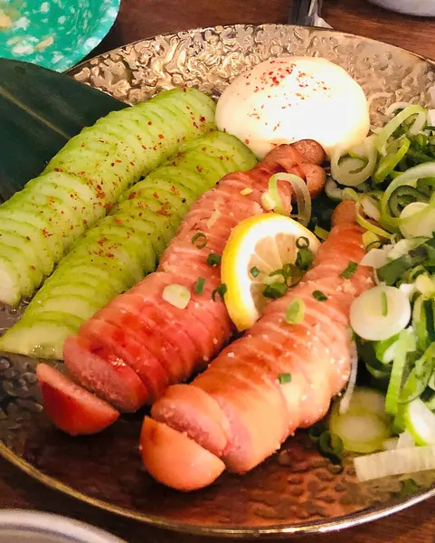 Limon, soya sosu ve salatayla servis edilen somon suşi ruloları..