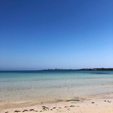 Beyaz kumlu ve mavi denizli güzel sahil