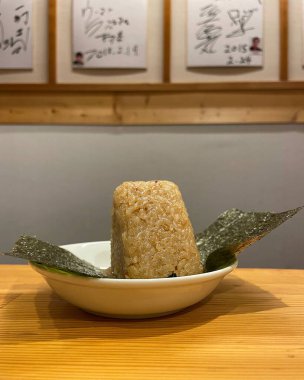 Domuz eti ve domuz etli Japon pilavı, pirinç ve ahşap tabakta deniz yosunu.