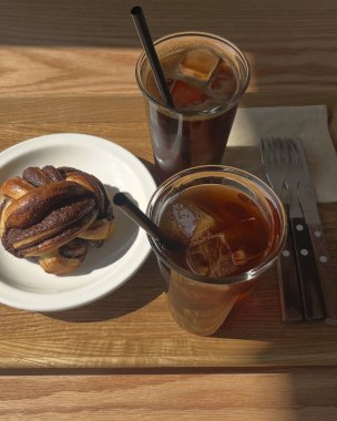 Kahve ve kruvasan masanın üzerinde cam bir fincanda.