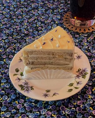 Kremalı bir parça pasta ve tabakta bir parça çikolata