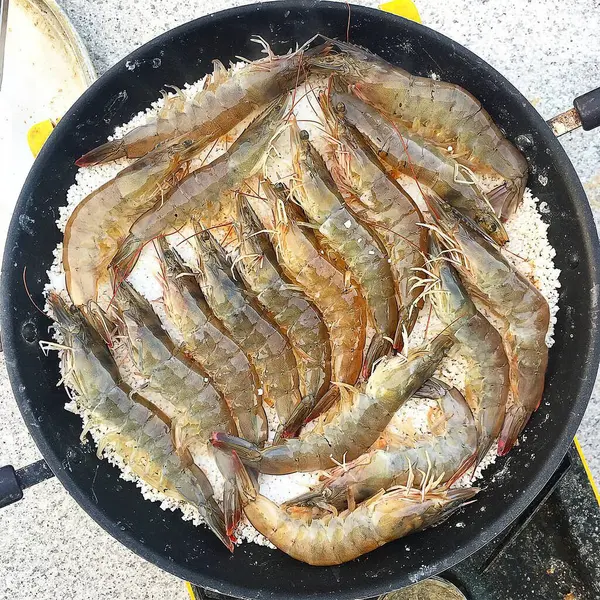 Tavada pişen taze karidesler.