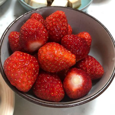 Beyaz arka planda bir kasede çilek