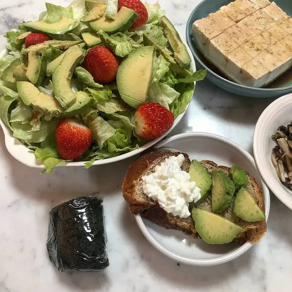 Sağlıklı kahvaltı. Masada avokado, ıspanak, domates ve peynir var..
