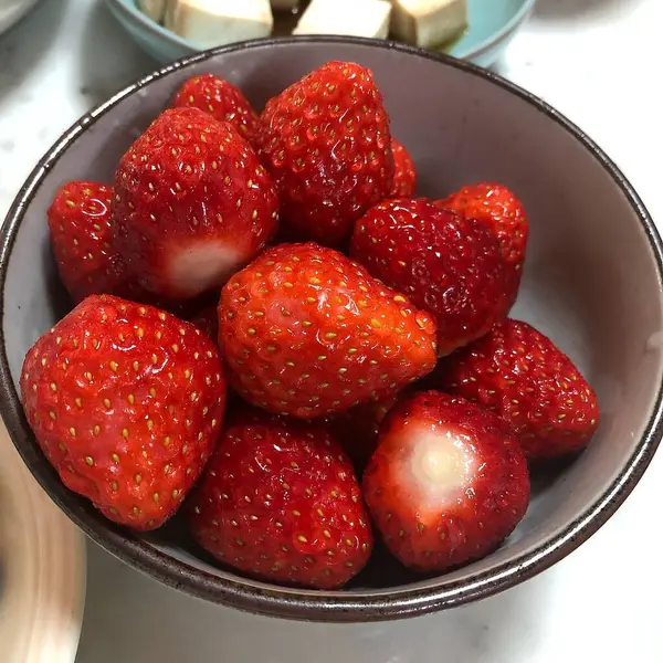 Beyaz arka planda bir kasede çilek