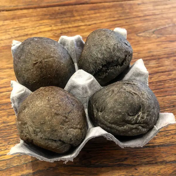 Siyah trüf mantarı beyaz tabakta, ahşap arka planda.