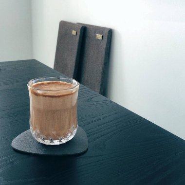 Çikolatalı kahve ve tahta masada bir bardak süt.