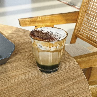 Sütlü buzlu kahve ve buzlu kahve. Elinde bir bardak buzlu kahve tutan kadın..