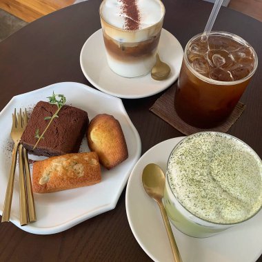 Bir fincan çay, bir bardak süt ve masada bir pasta.