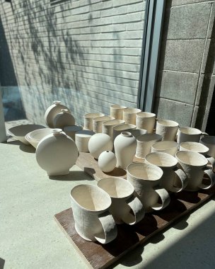 Tahta bir masada beyaz, siyah ve beyaz seramik bardakların yakın plan çekimi.