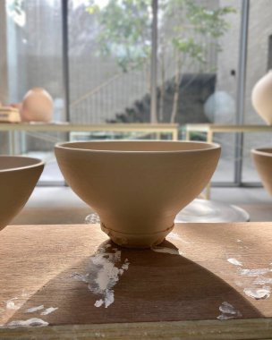 Seramik fincan ve çaydanlık masanın üstünde.