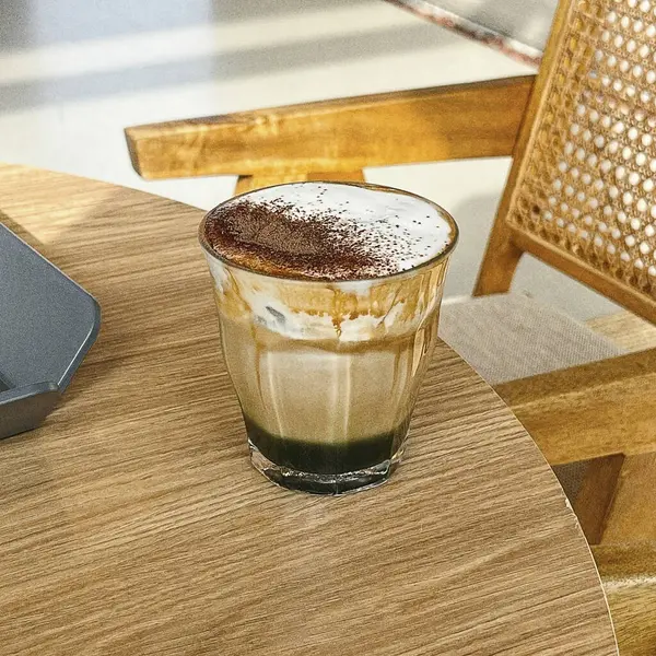 Sütlü buzlu kahve ve buzlu kahve. Elinde bir bardak buzlu kahve tutan kadın..