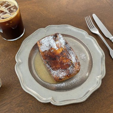 Bir fincan kahve ve kruvasanla ahşap bir masada