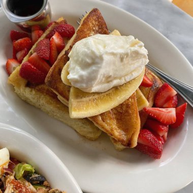 Kremalı ve beyaz tabakta meyveli Belçika waffle 'ı.