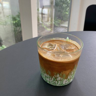 Kafedeki beyaz masada, nane yapraklı buzlu kahve..