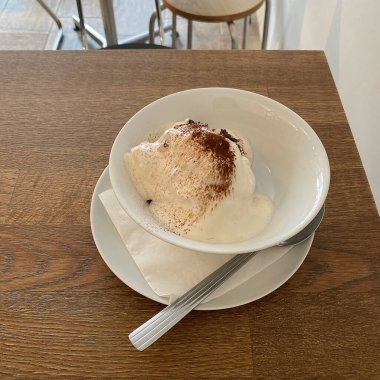 Vanilya soslu dondurma ve beyaz tabakta çikolata..