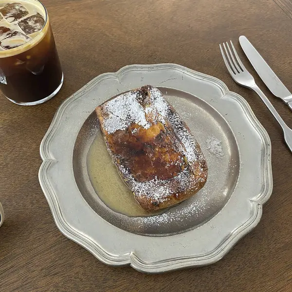 Bir fincan kahve ve kruvasanla ahşap bir masada