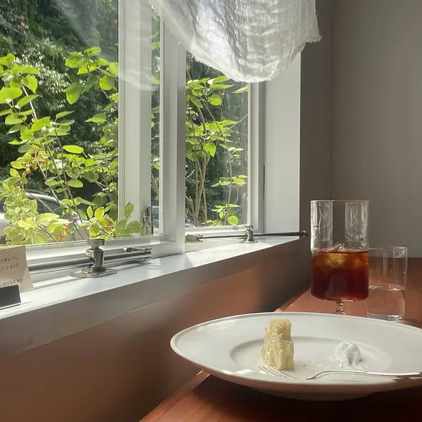 Masanın üzerinde beyaz bir pasta olan bir fincan çay..