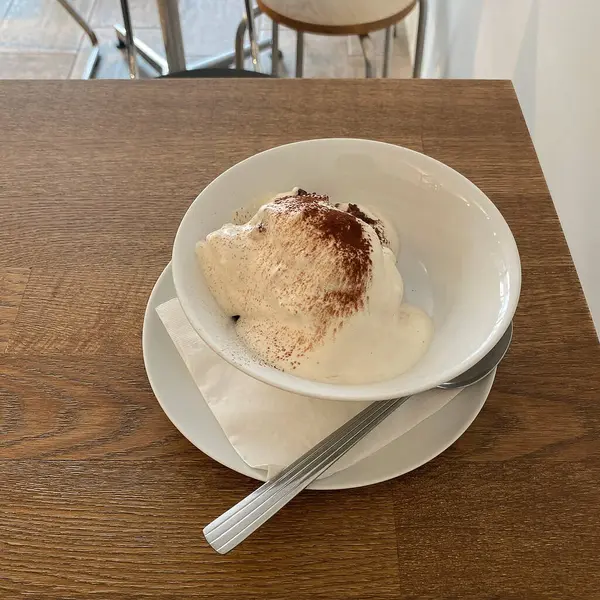 Vanilya soslu dondurma ve beyaz tabakta çikolata..