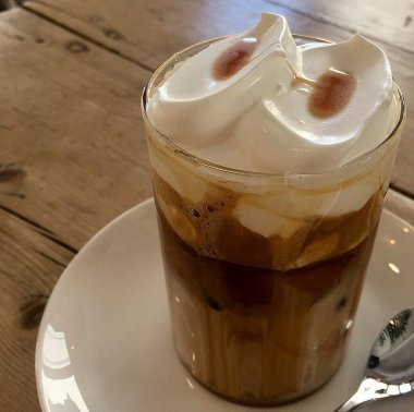 Sütlü buzlu kahve ve ahşap arka planda krema.