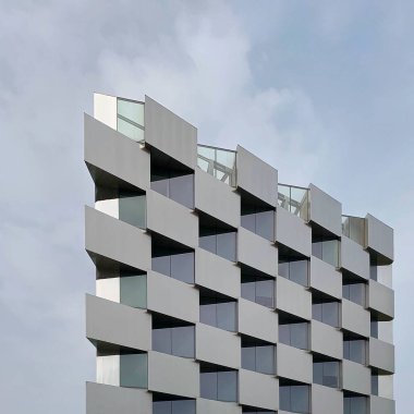 Gökyüzünde cam penceresi olan modern bir bina.