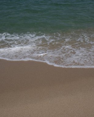 Kumsalda deniz köpüğü dalgası.