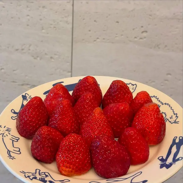 Beyaz ahşap bir masada taze çilekler.