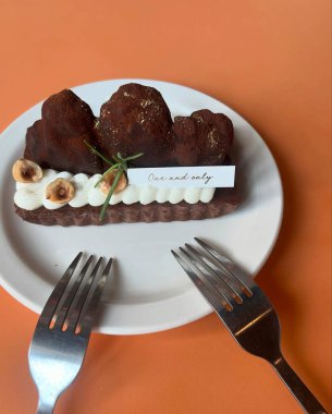 Fındıklı çikolatalı kek ve beyaz tabakta çikolata.