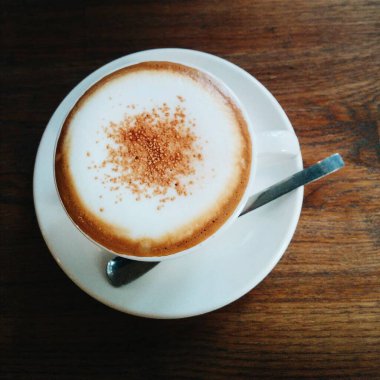 Ahşap masada kapuçino latte.